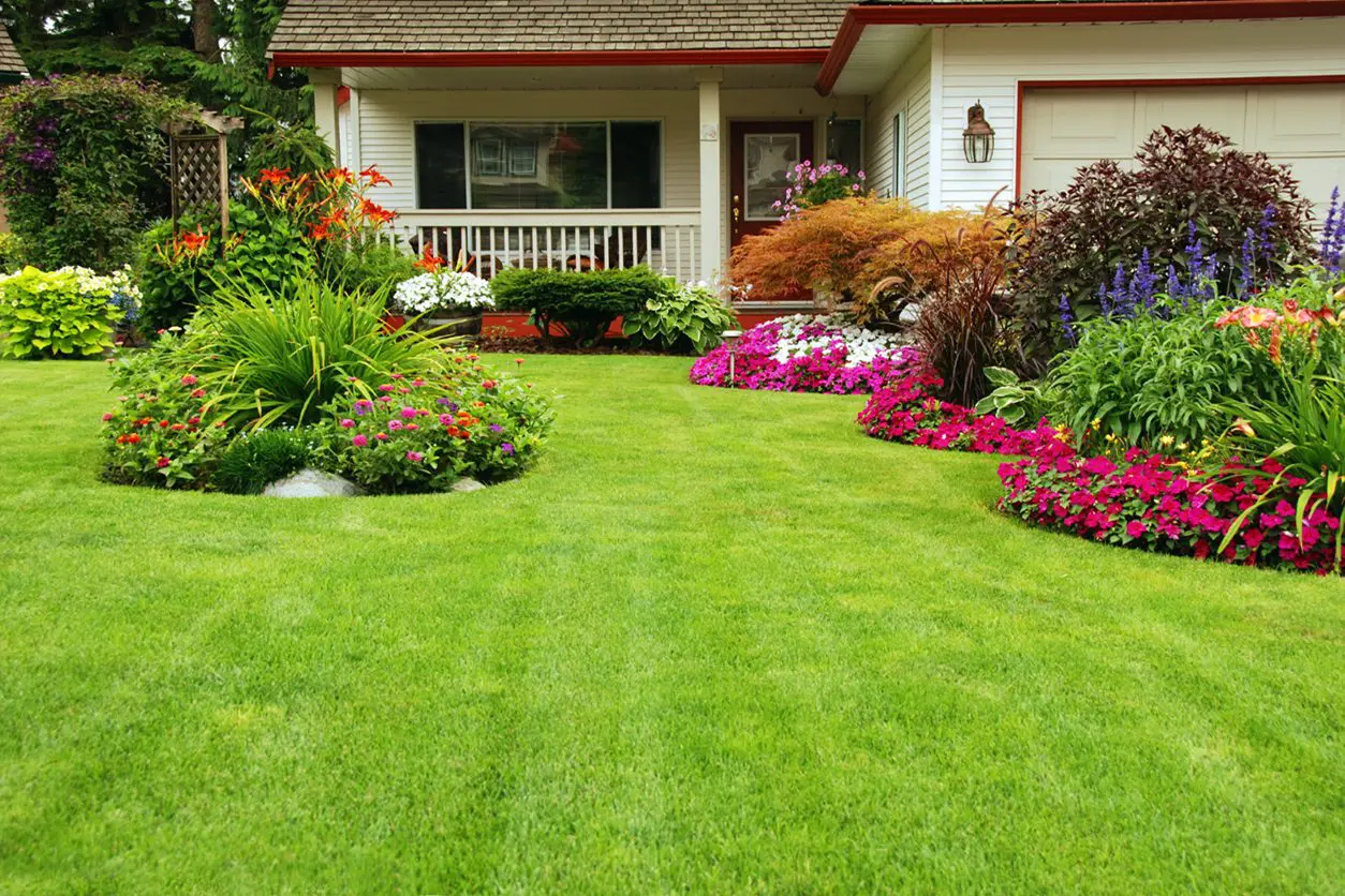 House with green lawn and flowerbeds.